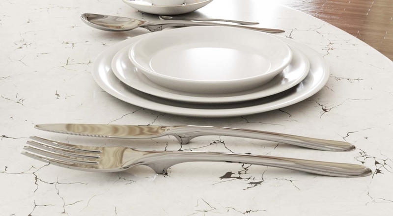 Floatware fork, knife and spoon floating above a marble table beside white plates